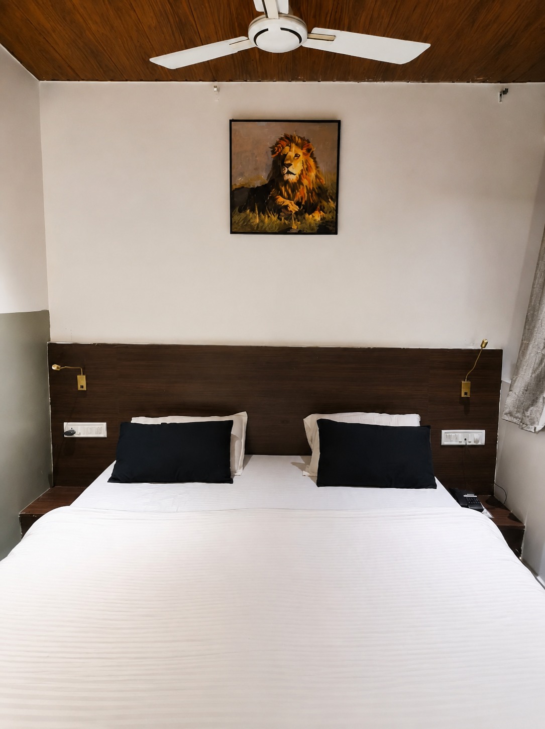 Guest room bed beneath a lion portrait